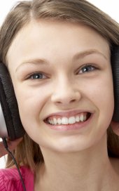 Smilende tenåringsjente med hodetelefoner